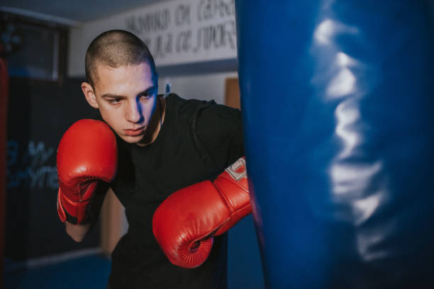 istock oung  young kickboxer doing some training on punching bag. 1203613488