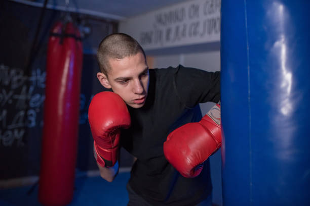 istock oung  young kickboxer doing some training on punching bag. 1203613490