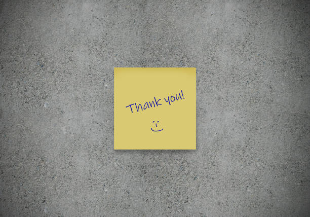 Thank you written on yellow sticker note on concrete wall