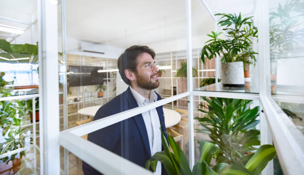 istock Young business man in co-working area, looking through window, Buenos Aires 1203616518