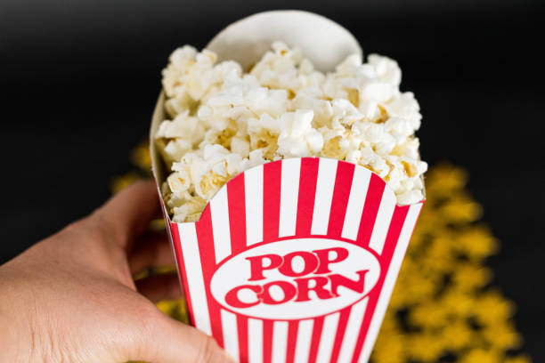 istock Woman hang holding a classic popcorn box 1203617191