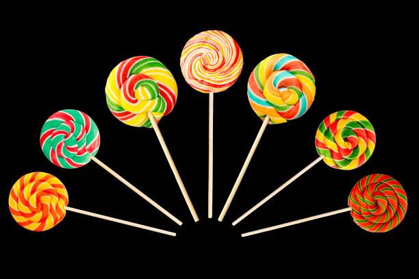 набор сладкой леденец круглой формы изолированы на черном фоне для украшения кондитерских изделий. многоцветные карамельные конфеты, сост - flavored ice lollipop candy affectionate стоковые фото и изображения