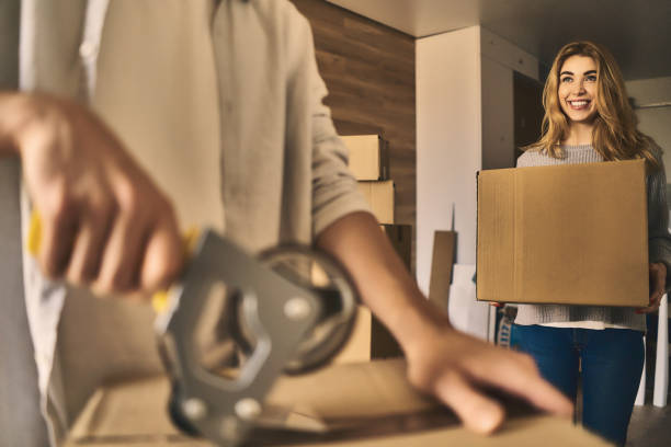 istock Attractive girl delivering a cardboard box to pack. 1203623556