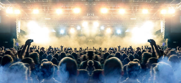 istock Concert stage, people are visible waving and clapping, silhouettes are visible 1203625137