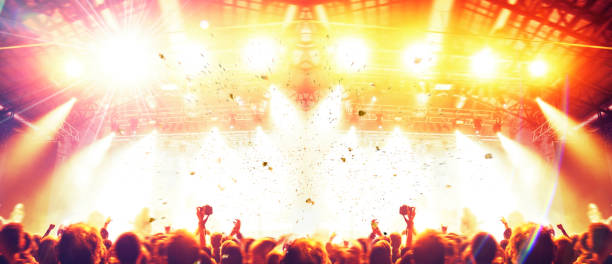 istock Concert stage, people are visible waving and clapping, silhouettes are visible 1203625139