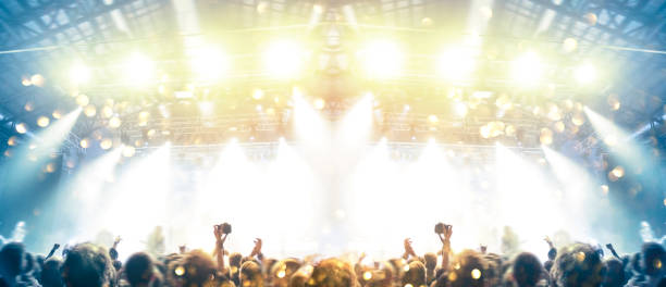 istock Concert stage, people are visible waving and clapping, silhouettes are visible 1203625176