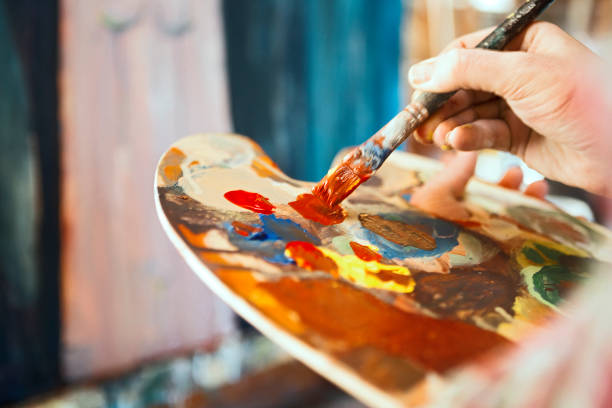 Artist Painting Artist Painting in studio paintbrush photos stock pictures, royalty-free photos & images