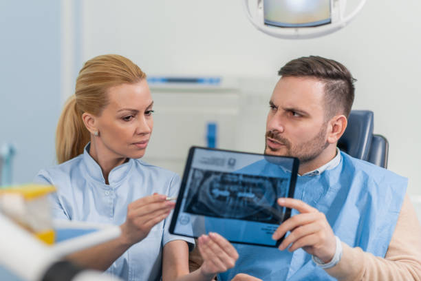 istock Dentist explaining x ray picture to patient 1203626690
