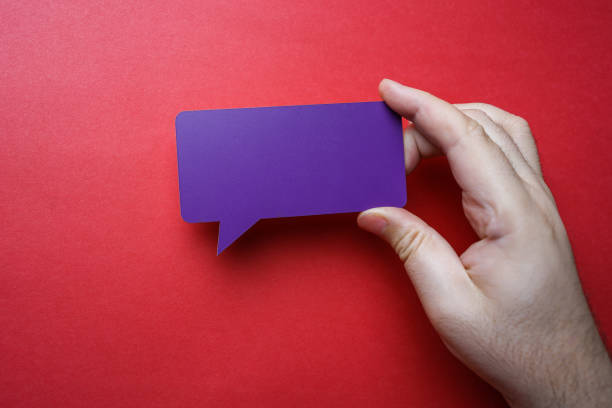Man holding blank purple speech bubble on red background.