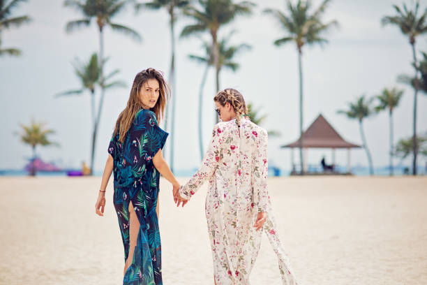 istock Girlfriends are walking and holding hands on the beach 1203631636