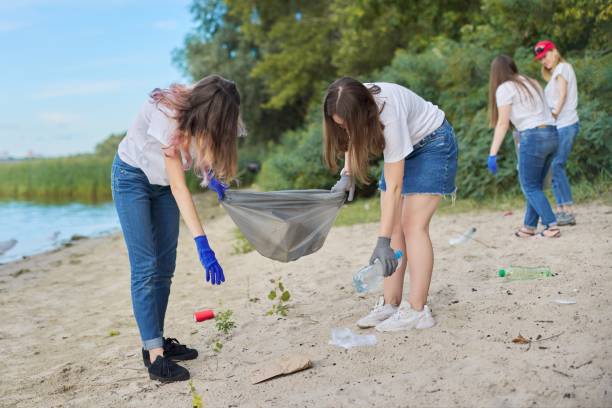 istock Group of students with teacher in nature doing cleaning of plastic garbage 1203632458