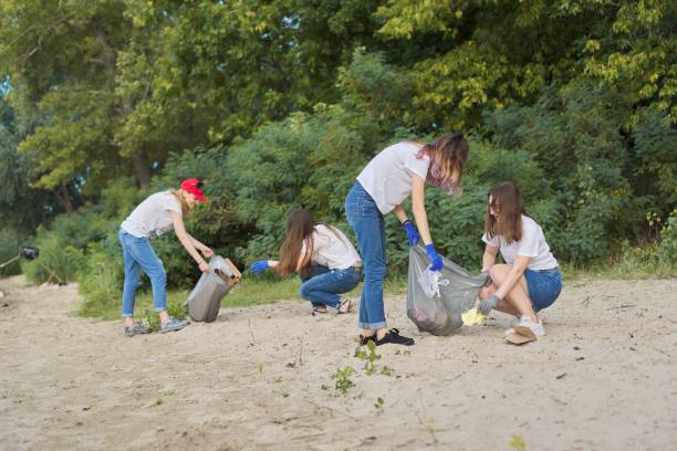 istock Group of students with teacher in nature doing cleaning of plastic garbage 1203632468