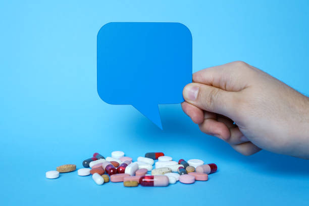 istock Pills and copy space with blue speech bubbles on blue background. 1203632488