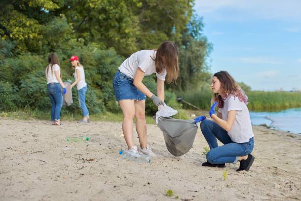 istock Group of students with teacher in nature doing cleaning of plastic garbage 1203632506