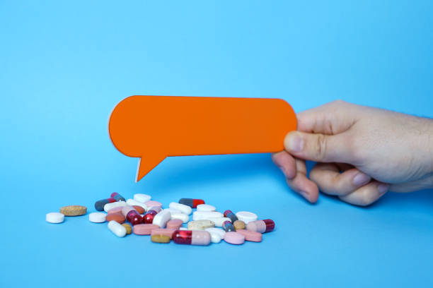 istock Pills and copy space with orange speech bubbles on blue background. 1203632520