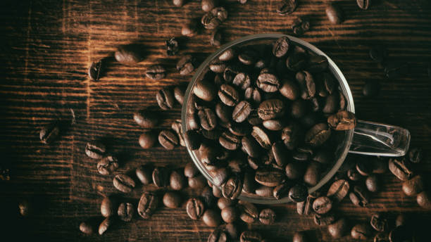 istock Background with coffee seeds in glass mug on wooden table 1203634045