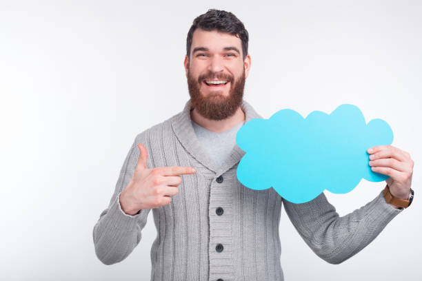 istock Handsome man is pointing at a light blue cloud he is holding . 1203634111
