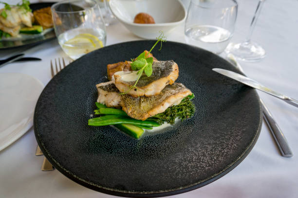 istock Dark plate with grilled fish fillets and green vegetables 1203642356