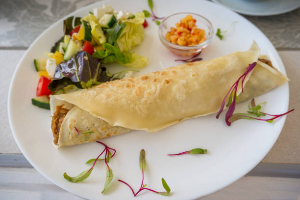 istock Close up of folded crepe with pulled pork and salad on the side with corn salsa 1203642364