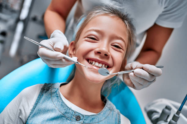 Young girl at dentist. Dentist hans with dental treatment Young girl at dentist. Dentist hans with dental treatment. Close up view. Front view pediatric dentistry stock pictures, royalty-free photos & images