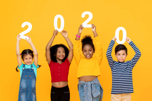 istock Cute mixed race kids smiling and holding 2020 numbers 1203642818