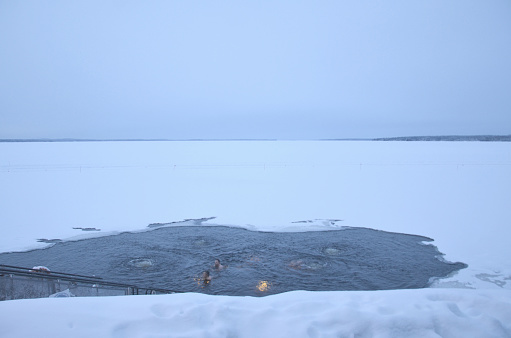 Finnish people swimming in the hole in the ice at Kaupinoja sauna. It is situated by lake Näsijärvi. The Finnish sauna is a substantial part of Finnish culture.