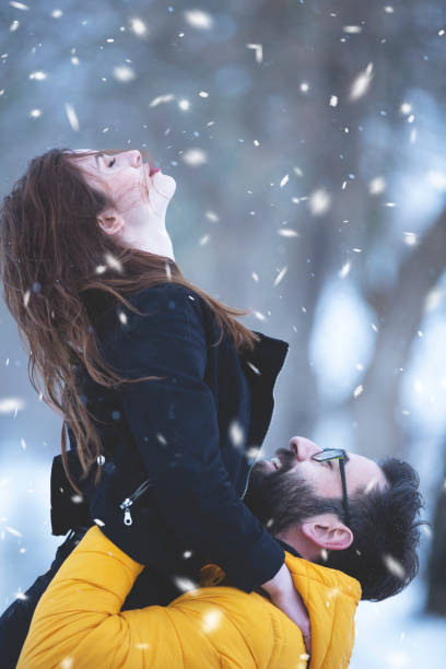 istock Young happy couple having fun in a snowy day 1203658239
