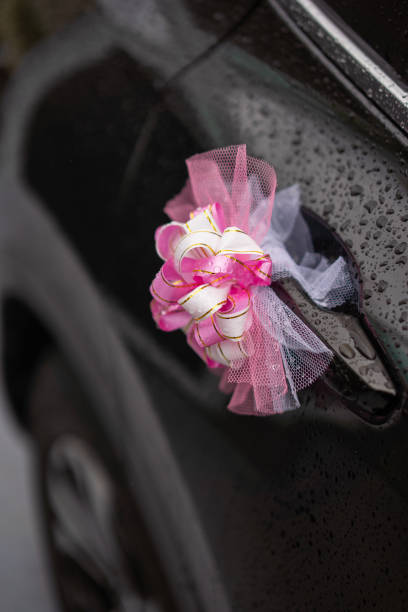 istock Purple ribbon decoration on wet wedding car 1203658254