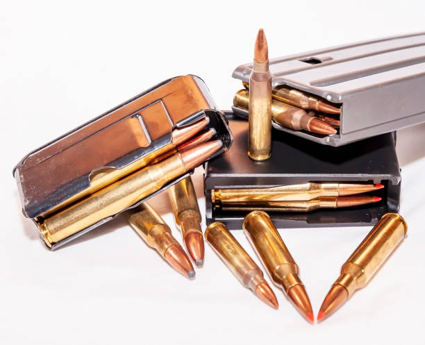 istock Three different caliber and size loaded rifle magazines with bullets next to them 1203665176