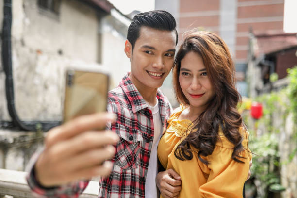 istock Asian couple sightseeing at town and selfie 1203665283