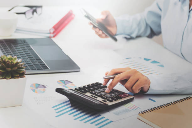 istock businesswoman working on desk using calculator laptop and mobile analyzing finance accounting in office 1203666077