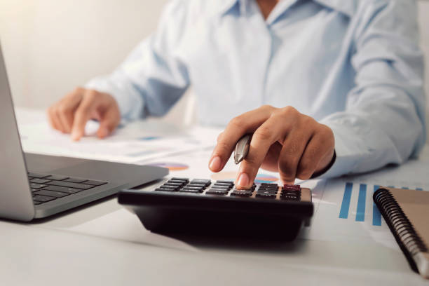istock businesswoman working on desk using calculator analyzing finance accounting in office 1203666079