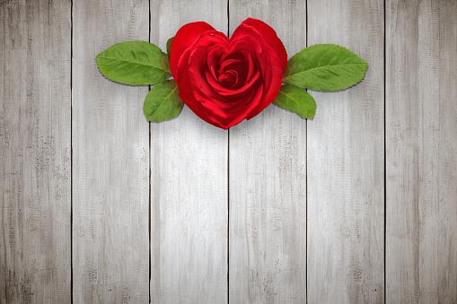 Red rose with heart shape on wooden table background. Valentines day