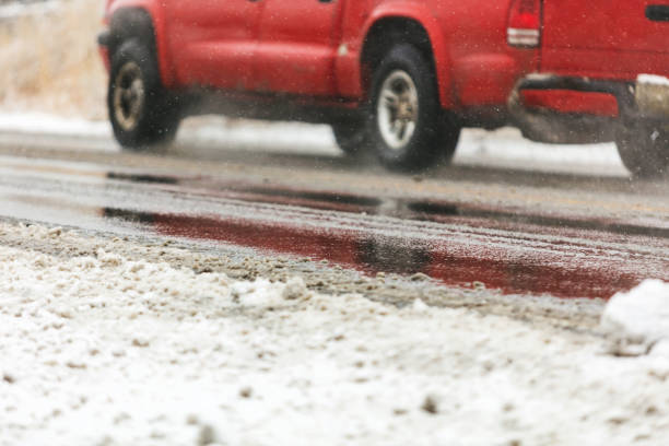 fahren auf snowy eisnassen straßen western united states winter travel series - drivers point of view country road snowing blizzard stock-fotos und bilder