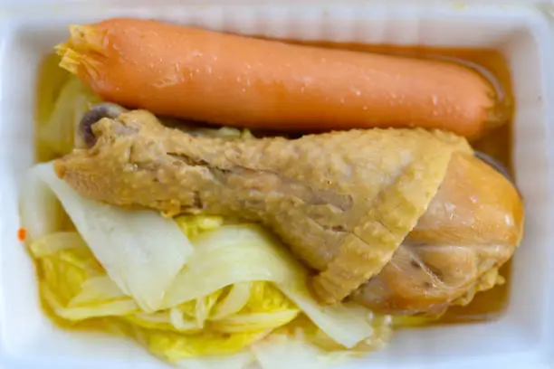 steamed chicken leg and sausage and cabbage in a take away box
