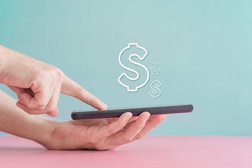Mujer usar gadget teléfono inteligente móvil ganar dinero en línea con el icono de dólar emergente. Tecnología fintech empresarial en concepto de smartphone. photo