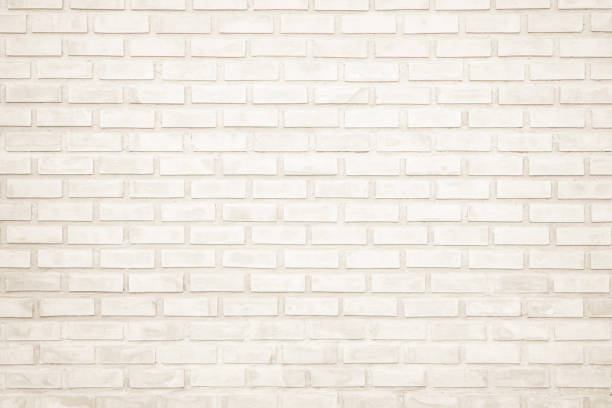 istock Background of wide cream brick wall texture. Old brown brick wall concrete or stone wall textured, wallpaper limestone abstract flooring/Grid uneven interior rock. Home or office design backdrop. 1203678212