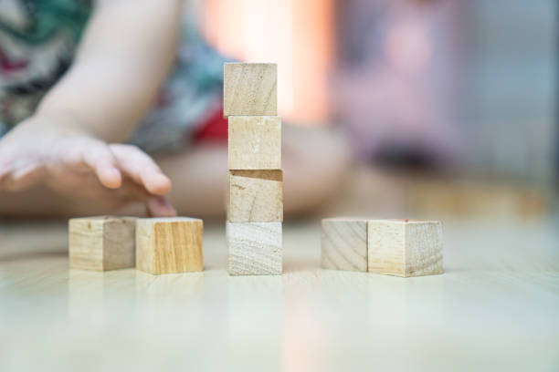 istock small wood block stacking with blurred kid background. 1203680318