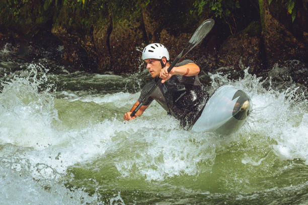 kanu-slalom-athlet trainiert auf einem fluss - wildwasserkanufahren stock-fotos und bilder