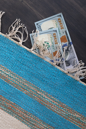 Hidden caches dollars bills under the mat