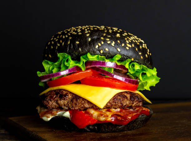 istock Black burger on a black background. Cheeseburger. Recipes. Fast food. 1203686537
