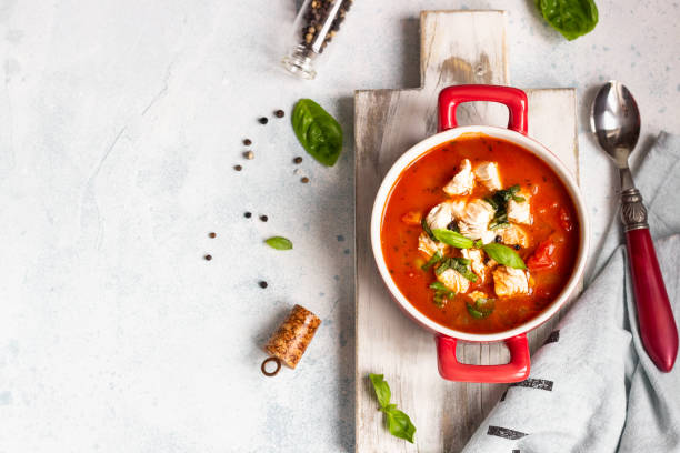 istock Warm tomato soup with chicken, vegetables and basil. Light concrete background. Copy space. Top view. 1203688690