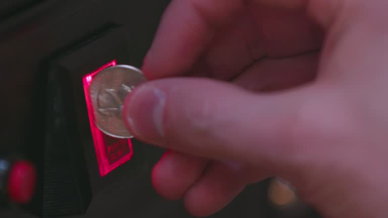 Inserting Quarter Into 25 Cent Arcade Machine Coin Slot