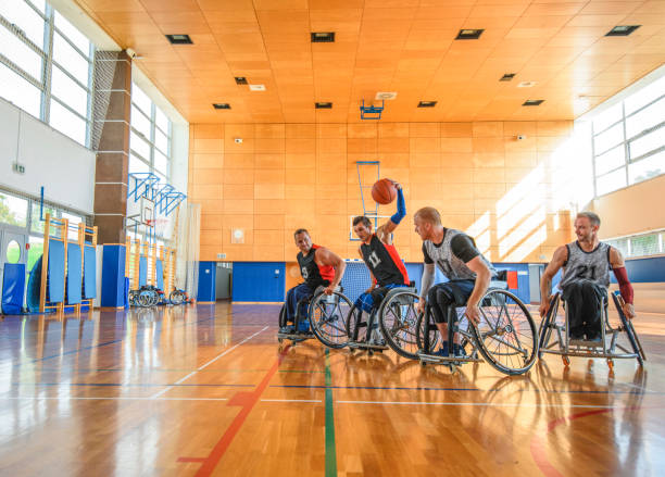 giocatori di basket in carrozzina maschi che combattono a metà campo - basket su sedia a rotelle foto e immagini stock