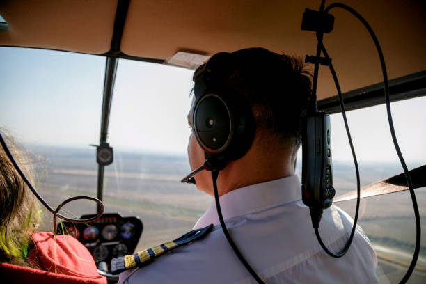 istock Pilot with passenger in helicopter cockpit 1203693781