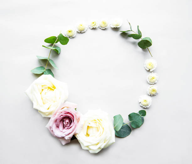 istock Decorative circle frame with pink and white roses and leaves on white background. Flat lay 1203694064
