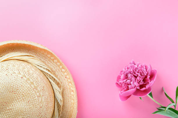 istock Beautiful pink peony and straw hat on pink background. Flat lay, top view, copy space. 1203694173