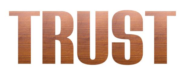 istock TRUST word with brown wooden texture on white background. 1203697402