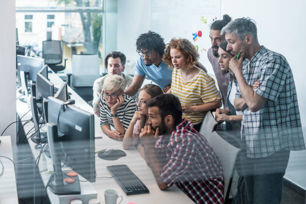 istock Team of worried computer programmers working on desktop PC in the office. 1203697829