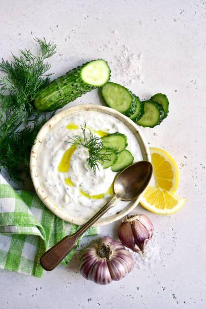 Tzatziki - traditional greek yogurt sauce Tzatziki - traditional greek yogurt sauce in a bowl on a white slate, stone or concrete background. Top view with copy space. tzatziki stock pictures, royalty-free photos & images